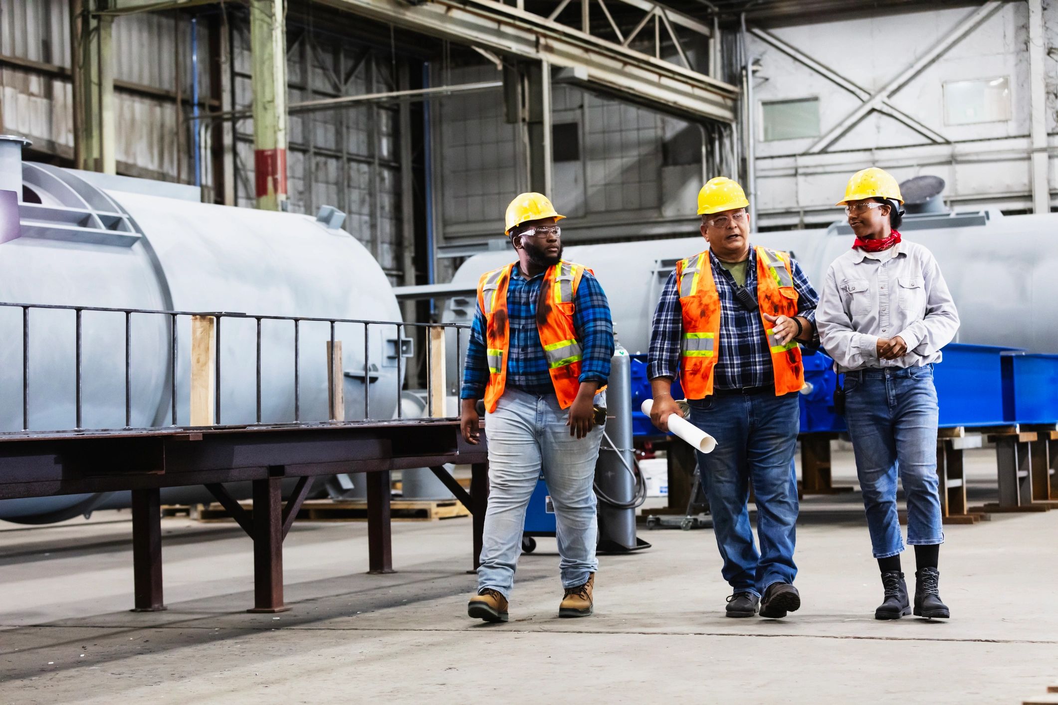 Industrial professionals discussing plans inside a steel fabrication facility